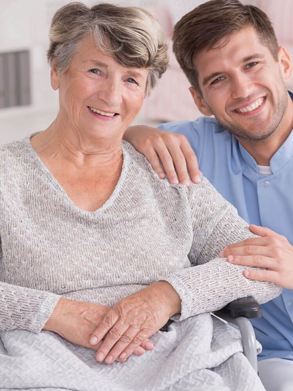 smiling-carer-with-senior-in-rest-home-PC34NGJ.jpg